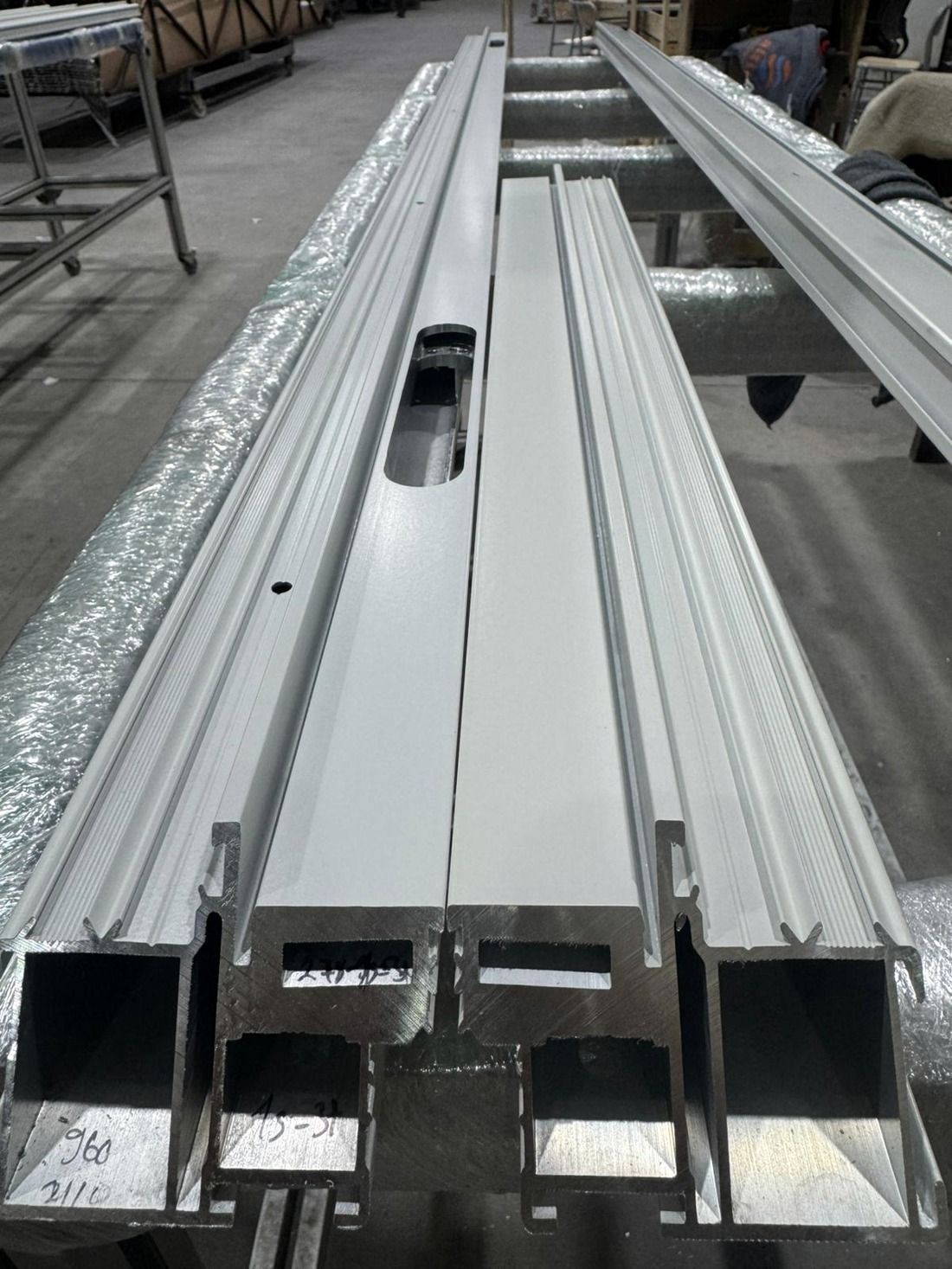 Powder-coated white aluminium profiles with machined slots